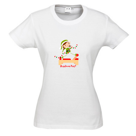 white round neck womens tee with an elf performing front splits pilates exercise on the reformer carrying christmas lights - with the title christmas prep