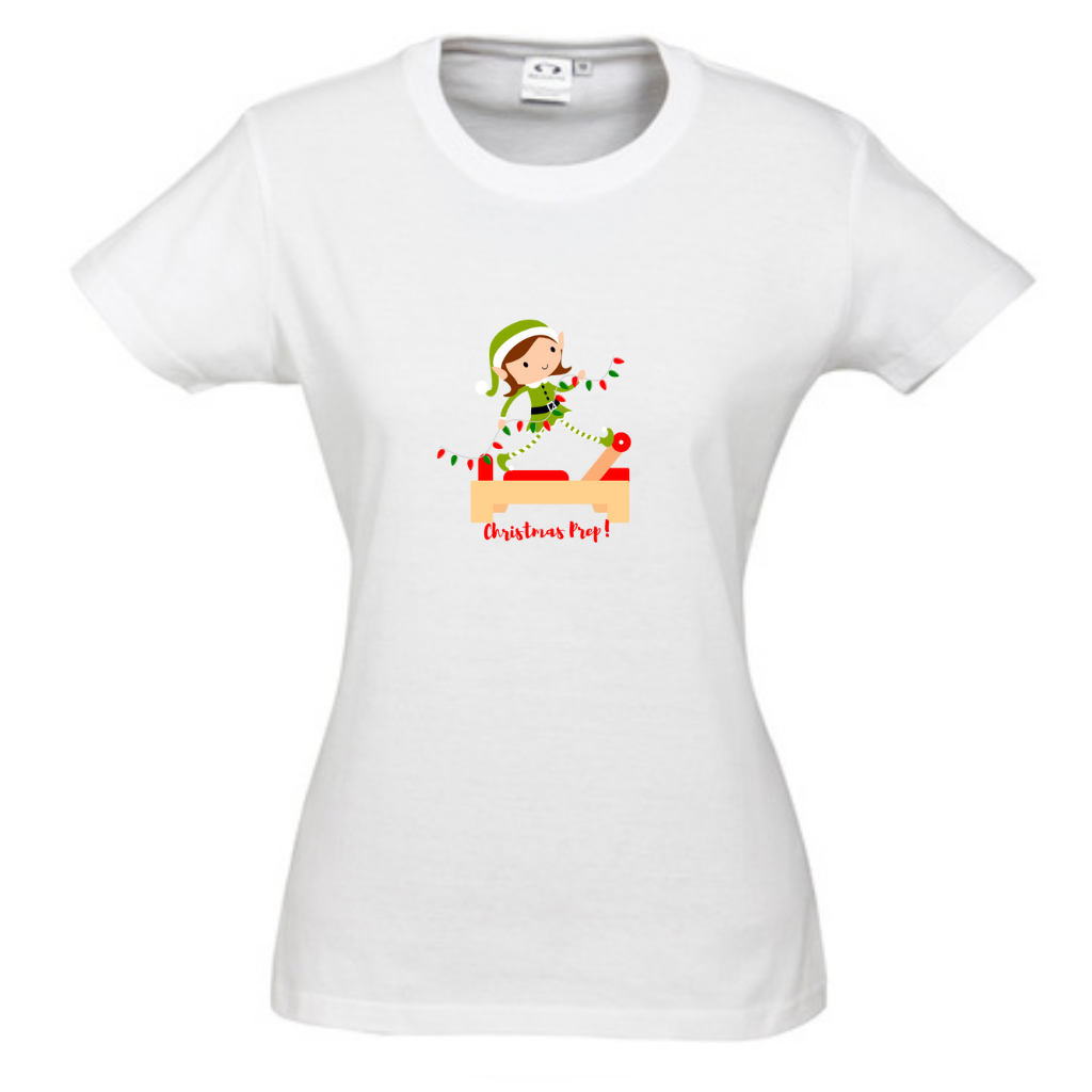 white round neck womens tee with an elf performing front splits pilates exercise on the reformer carrying christmas lights - with the title christmas prep