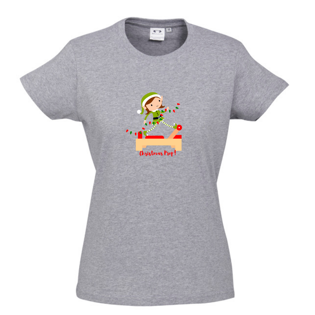 grey merle round neck womens tee with an elf performing front splits pilates exercise on the reformer carrying christmas lights - with the title christmas prep