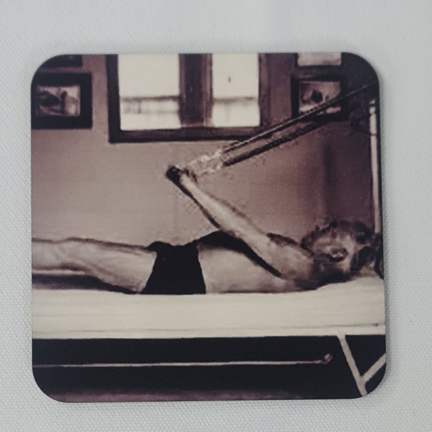 classic black and white photo of joseph pilates performing assisted hundred on the trapeze table.
