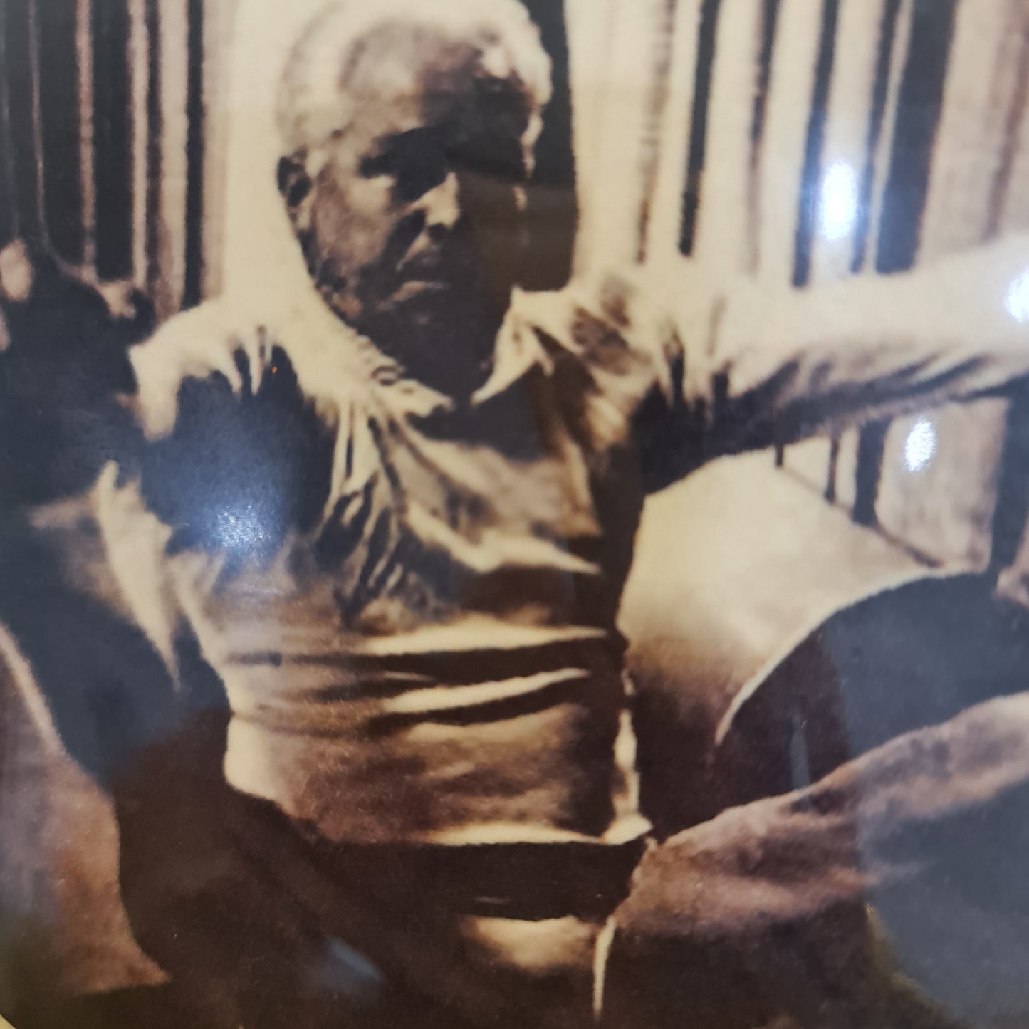 Round cork coaster featuring joseph pilates performing open leg rocker - one of his mat exercises